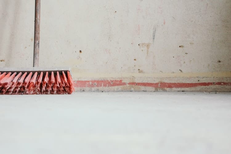 A broom leaned against a wall.